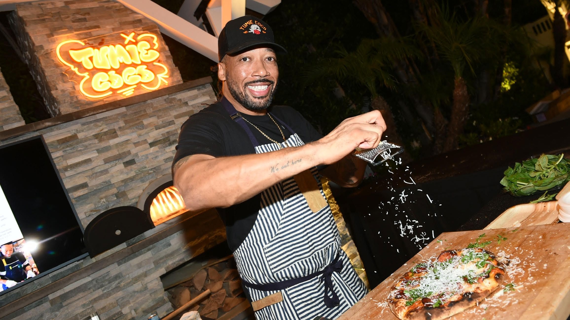 Chef Jason Fullilove seasoning food over live fire